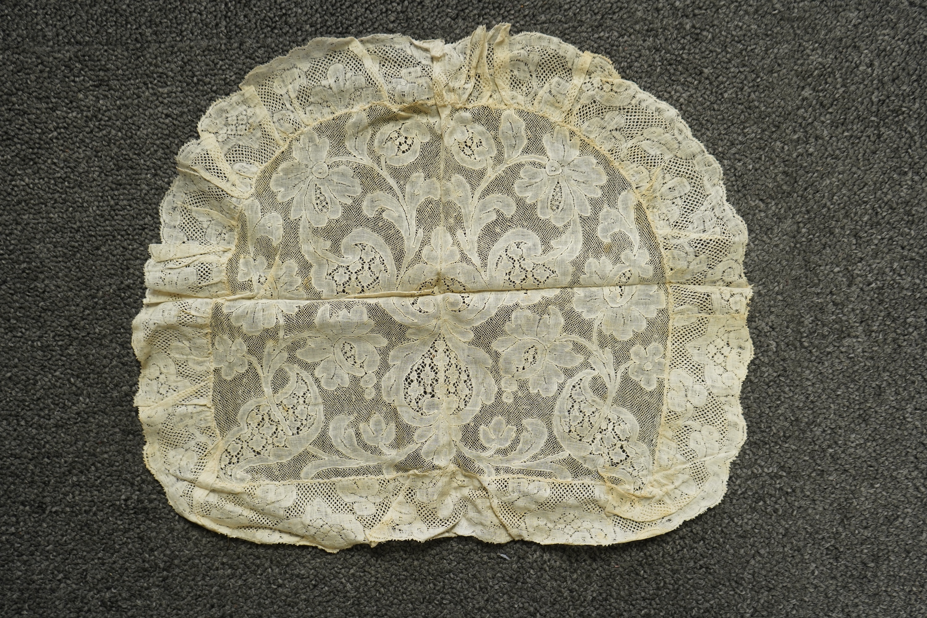 A collection of 18th century needle and bobbin lace. Including an 18th century wide pair of joined Valenciennes lace lappets, a similar 18th century cap back, an ornately worked Point de Alencon cap crown and another sim